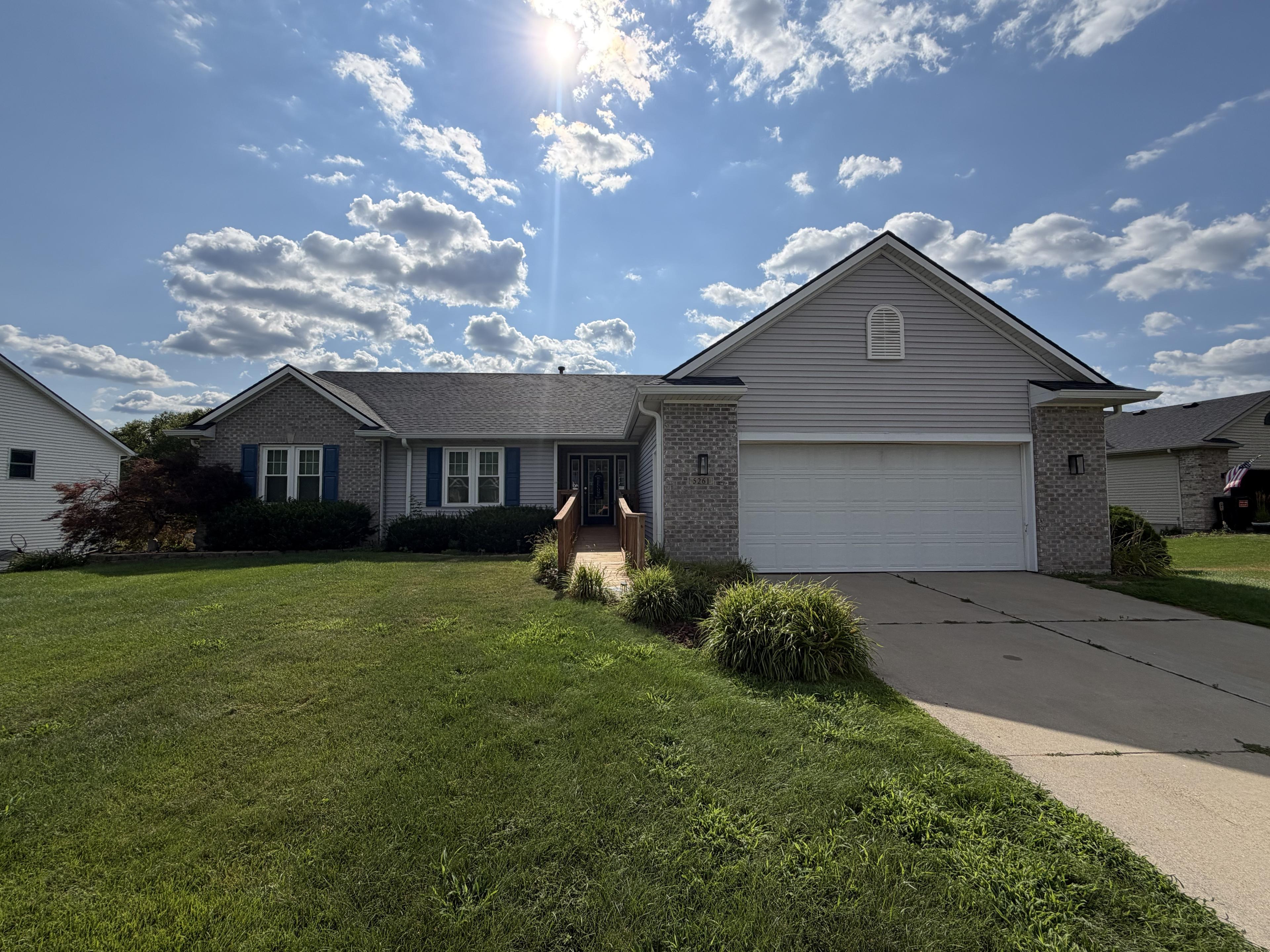 Front of the home — brick ranch with an attached garage and a wide, level front lawn