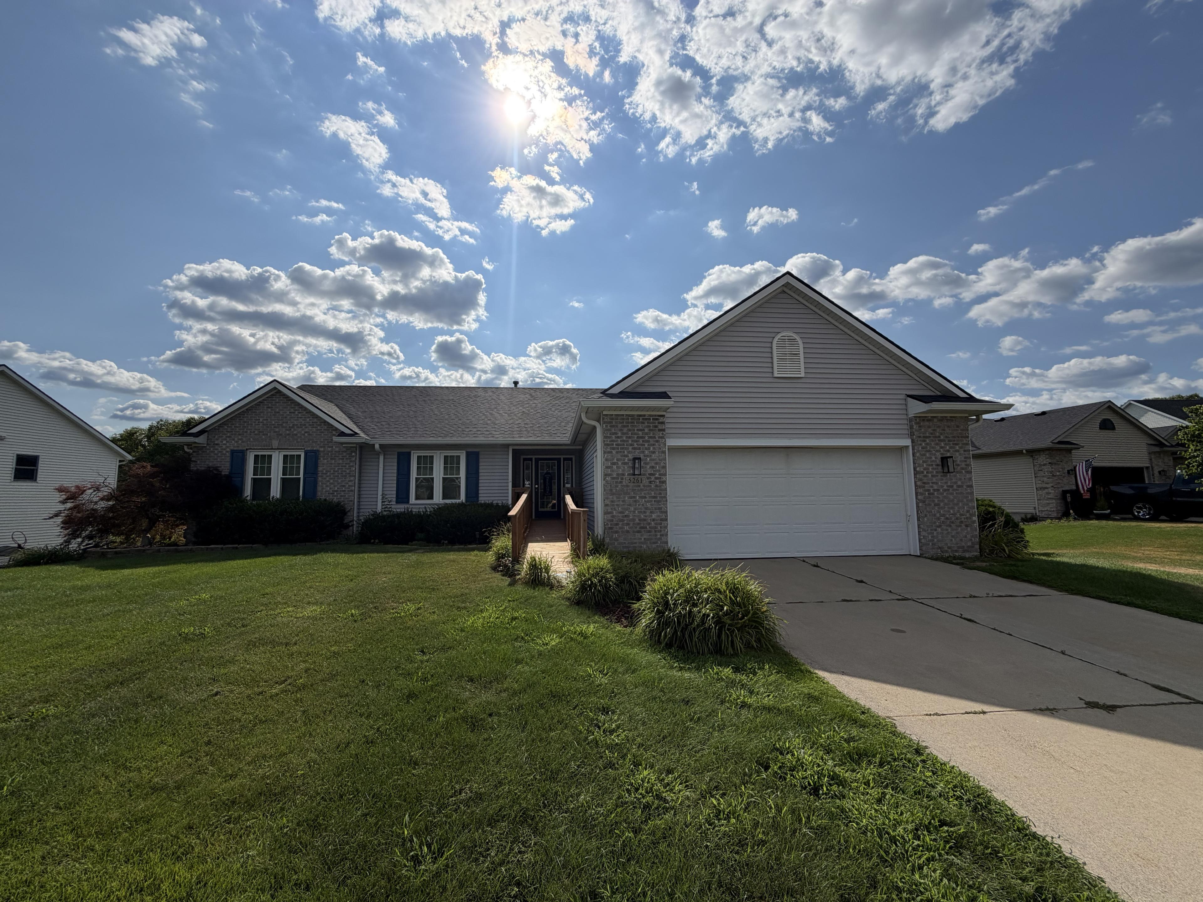 Front exterior of the home on a sunny afternoon with a landscaped walkway