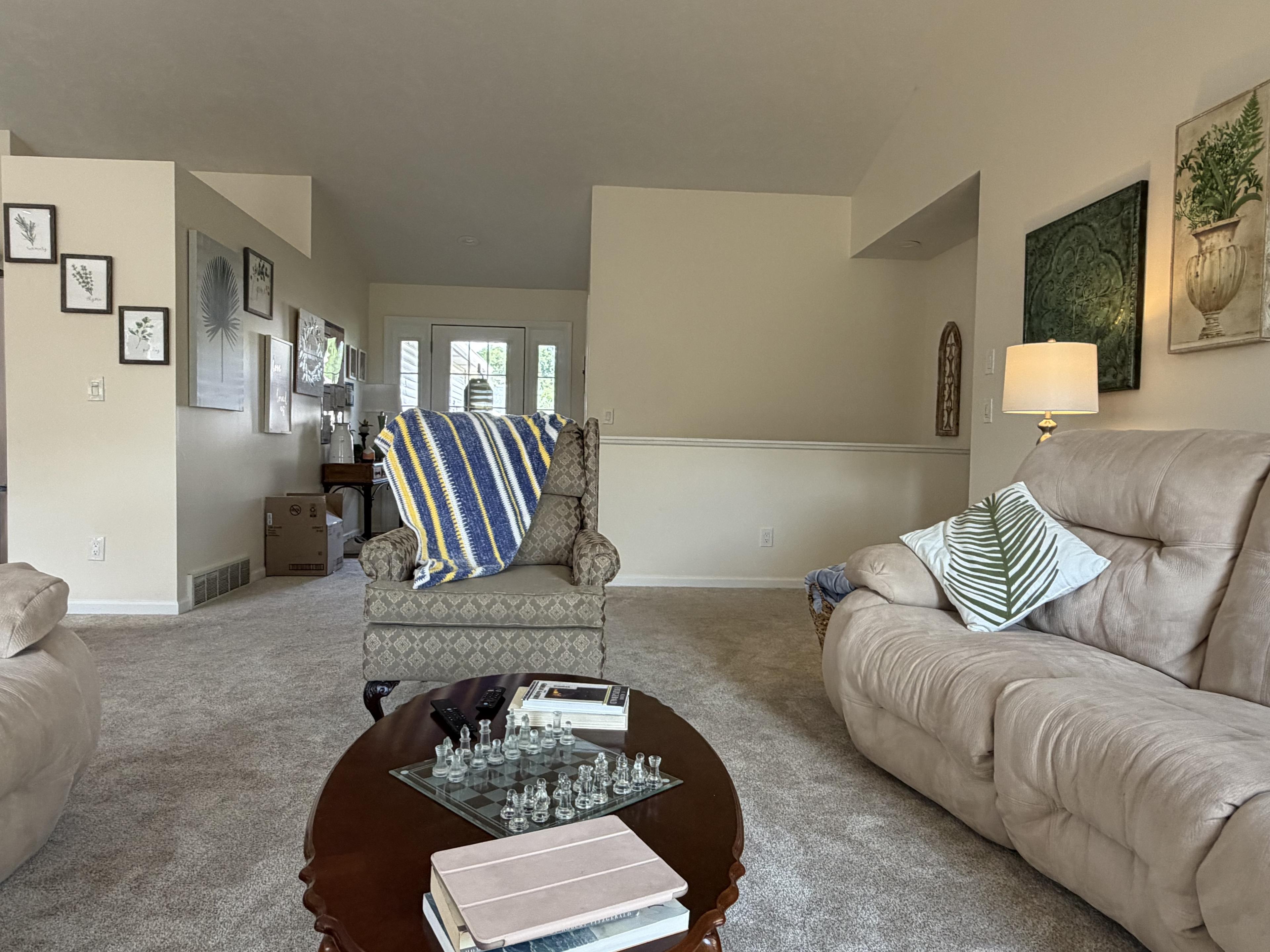 Sitting room with sofas, a chess set on the coffee table, and natural light