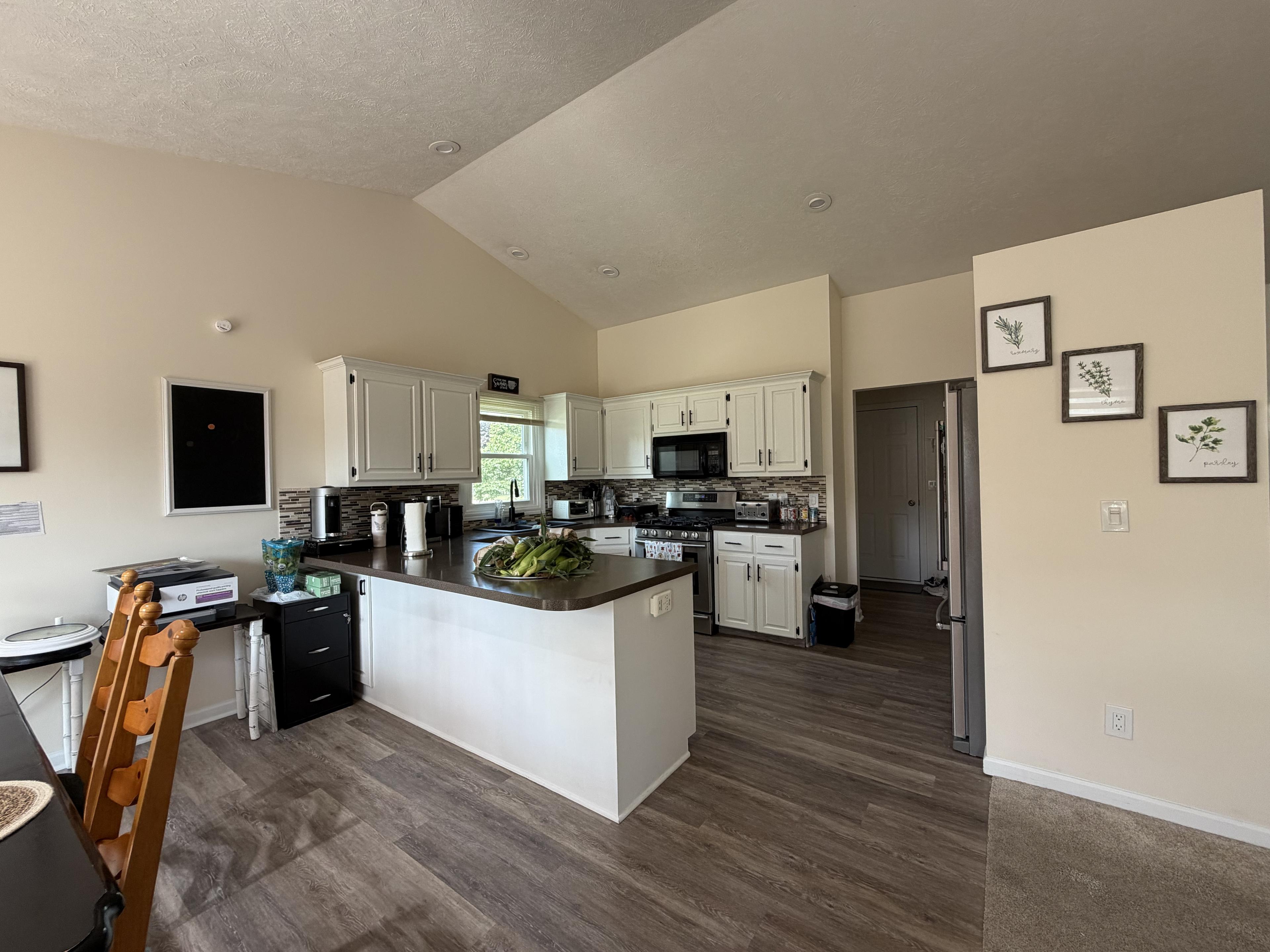 Home-style kitchen with a breakfast bar peninsula and white cabinetry