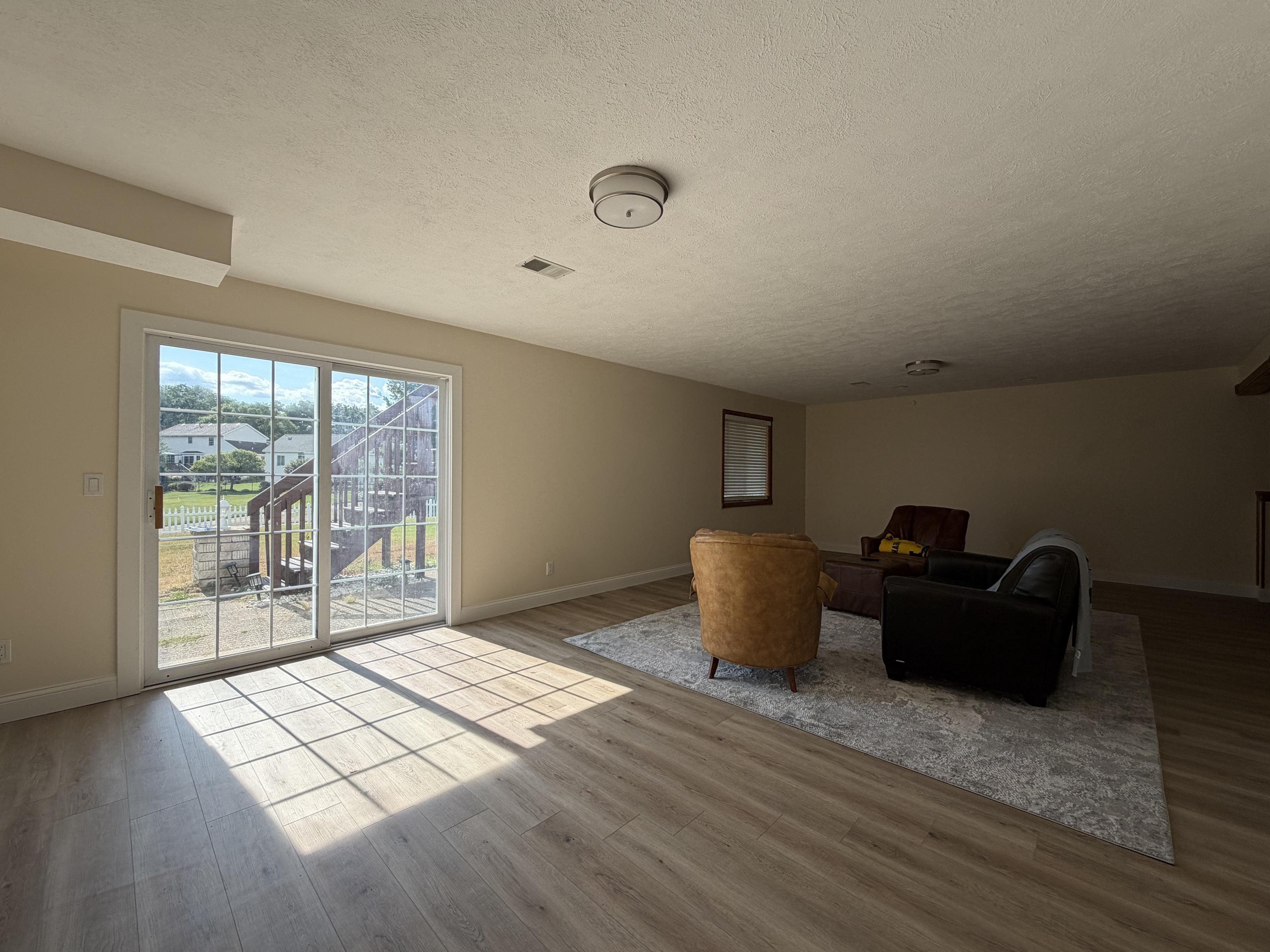 Lower-level family room with a sliding door out to the backyard