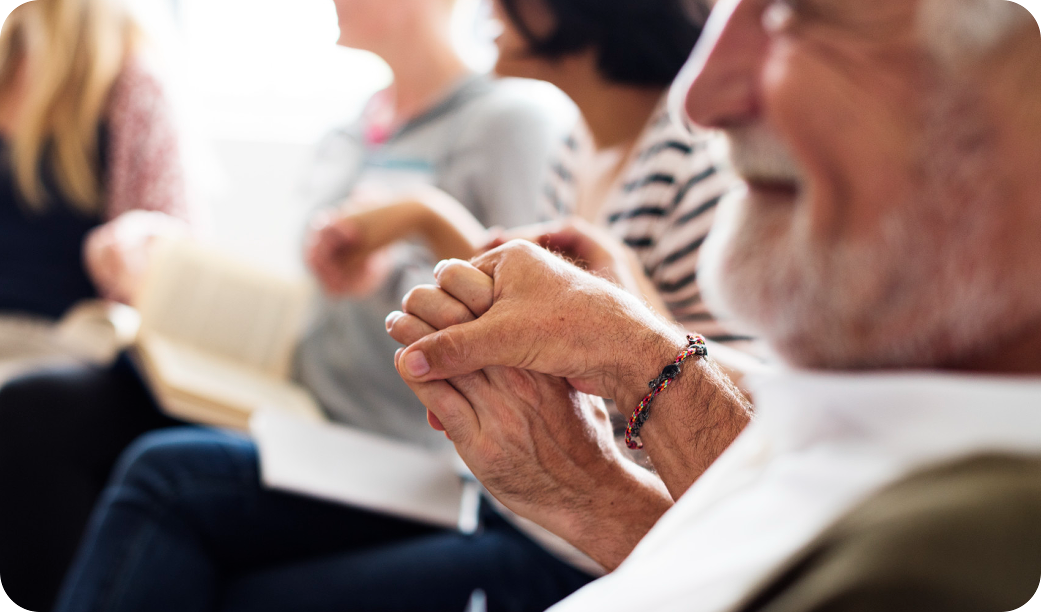 Family members holding hands in support and prayer